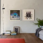 Framed artwork on living room wall above floorboards.